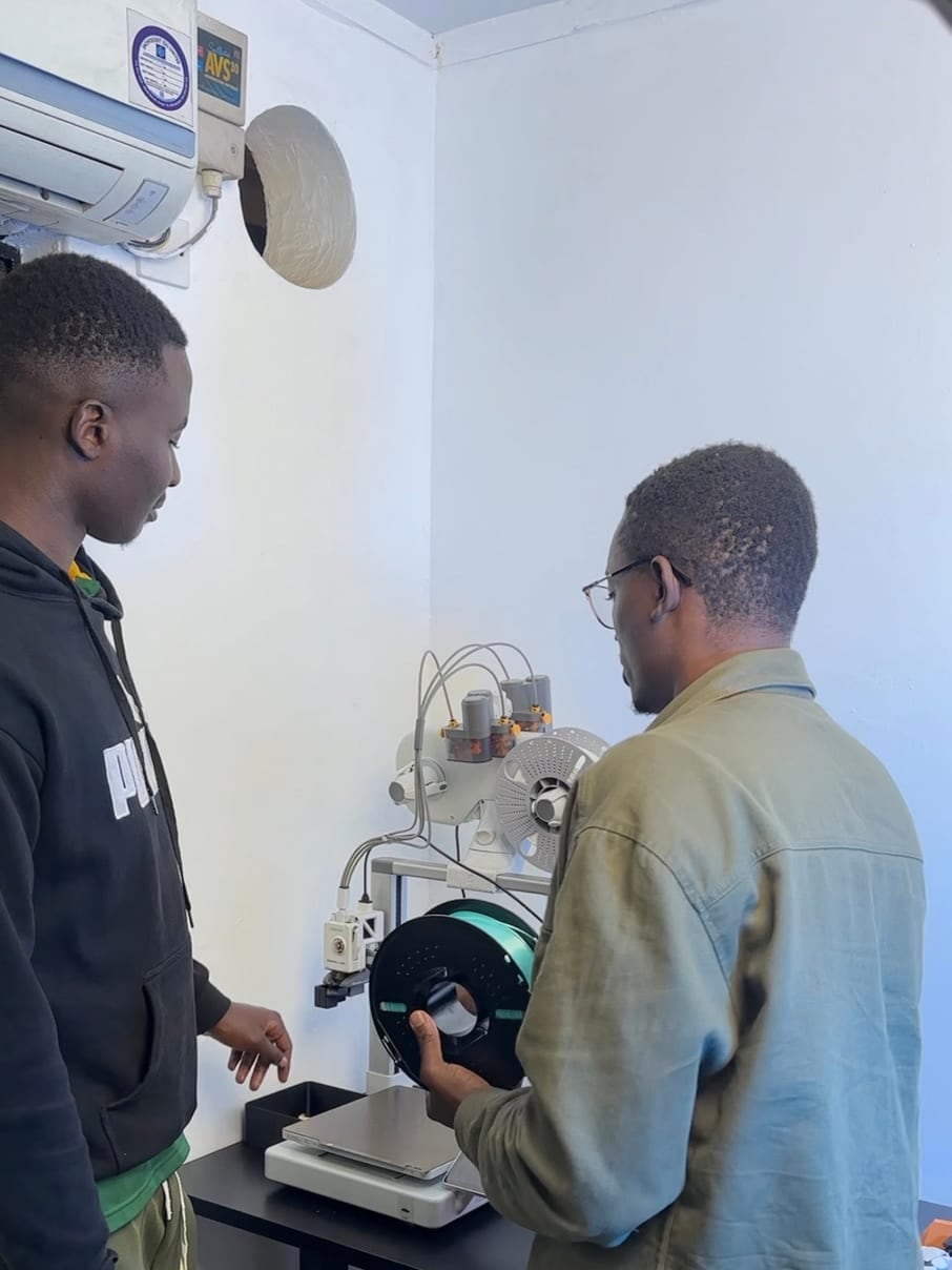 Tynmas Labs team members reviewing a 3D printer and filament together